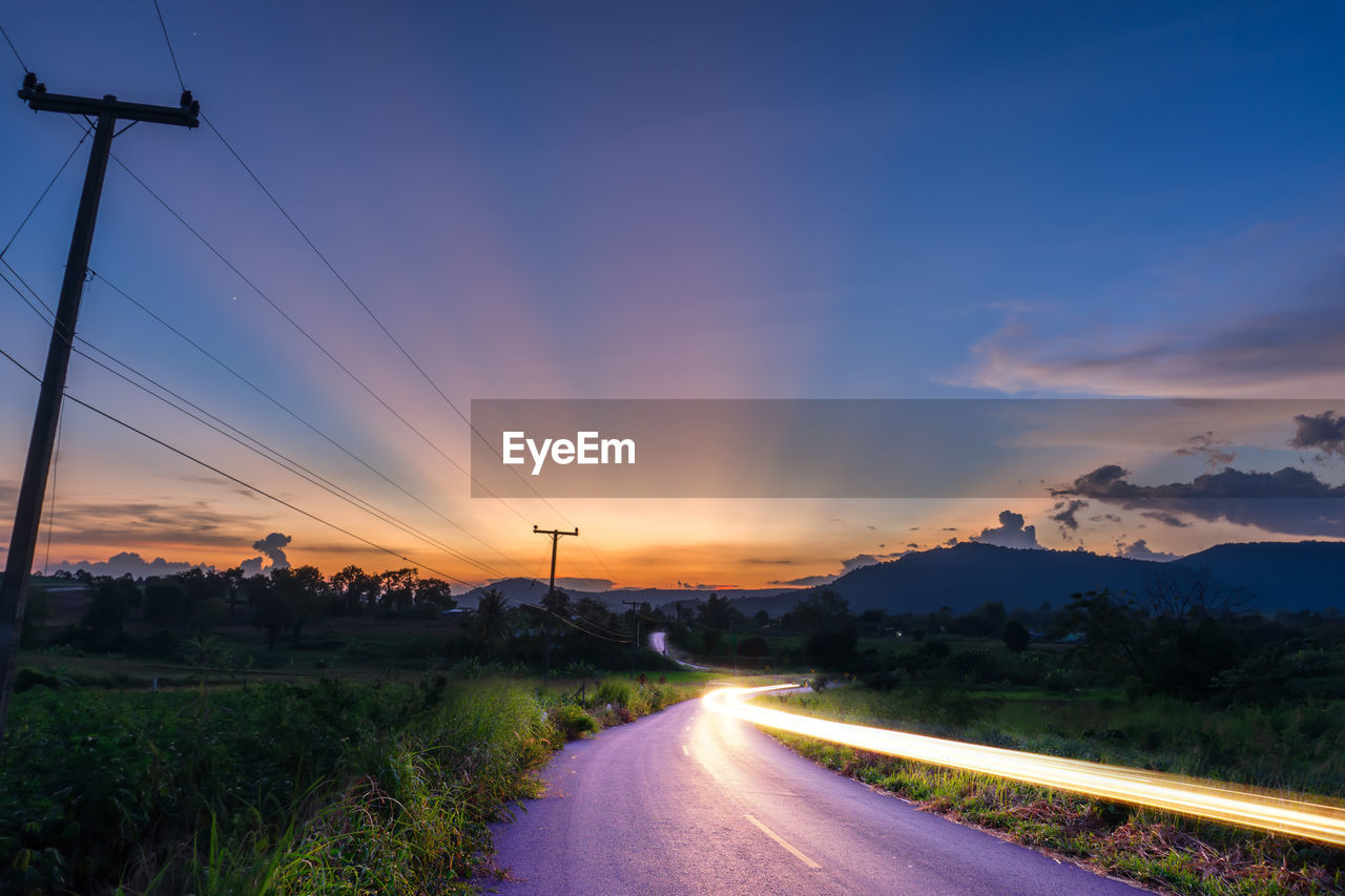 Light trail on road against sky during sunset