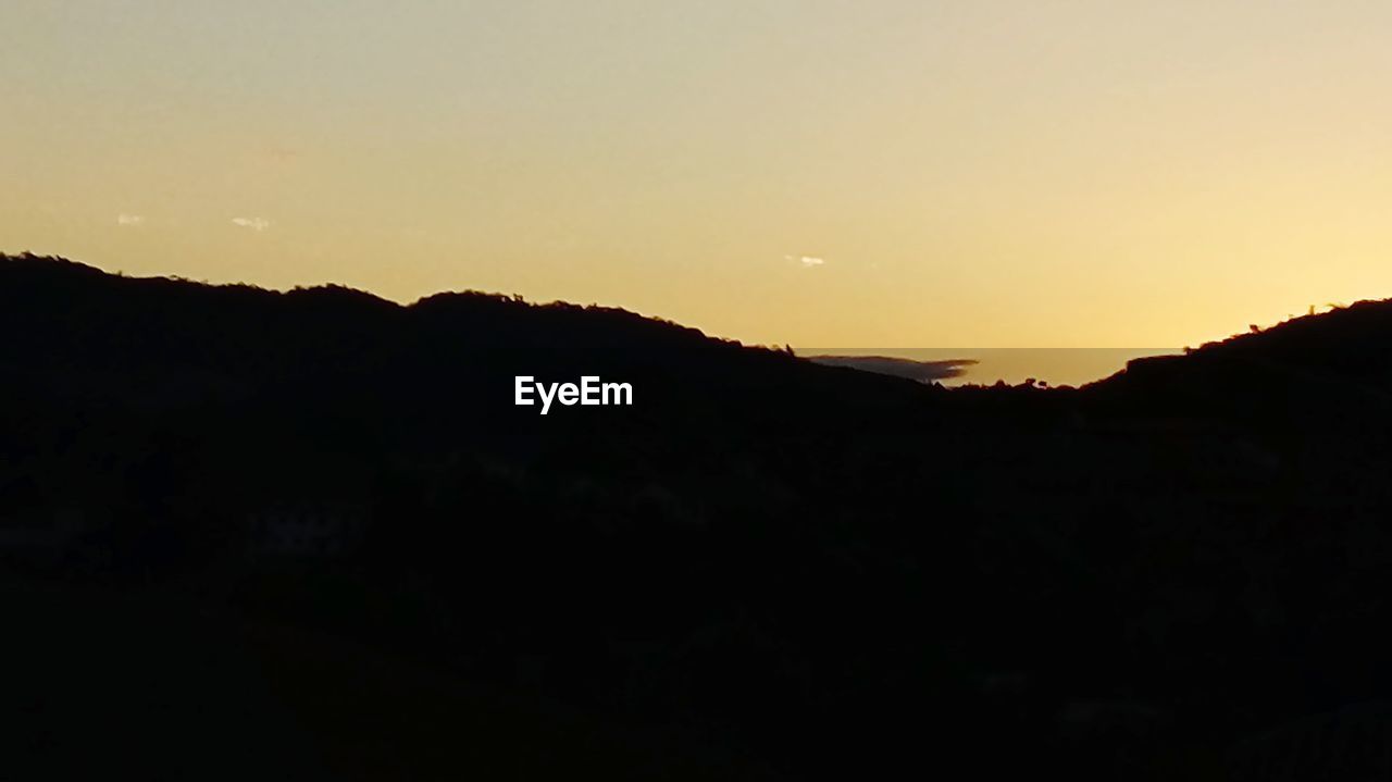 SILHOUETTE MOUNTAINS AGAINST SKY AT SUNSET