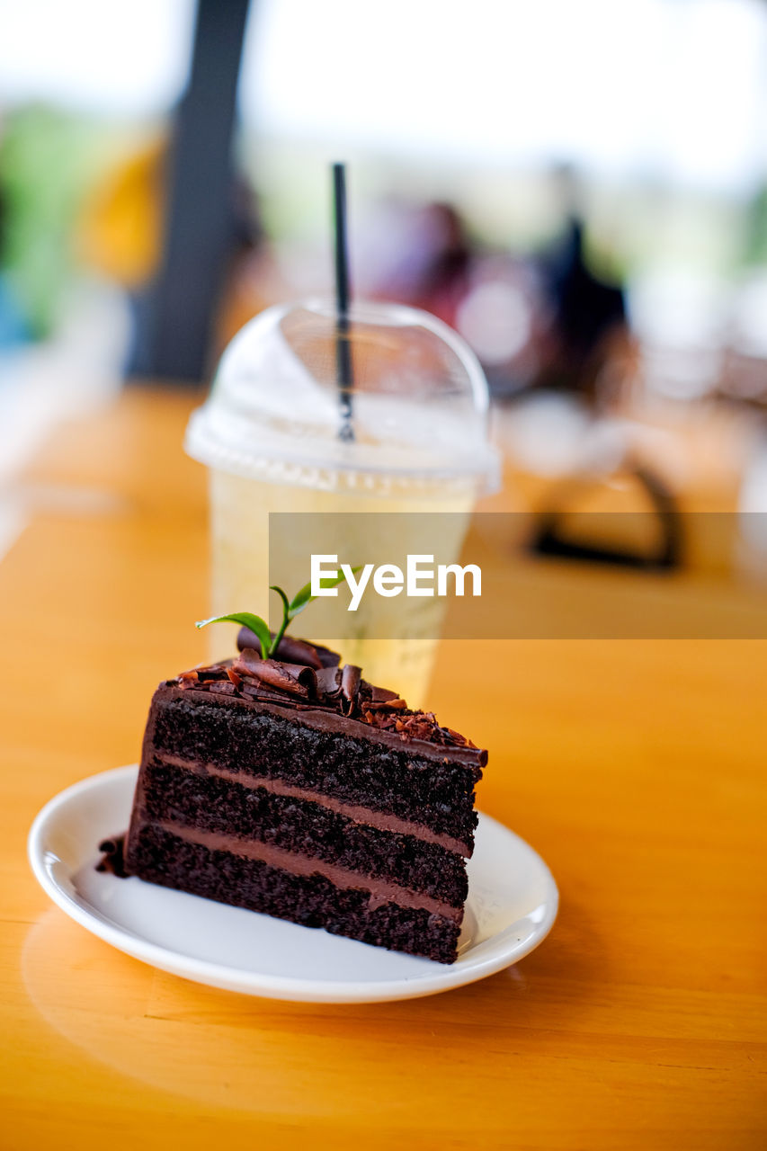 food and drink, food, dessert, sweet food, sweet, cake, birthday cake, table, chocolate, baked, plate, freshness, chocolate cake, focus on foreground, temptation, fruit, slice, close-up, unhealthy eating, drink, sweetness, no people, indoors, produce, meal, refreshment