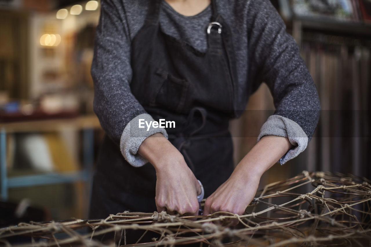 Midsection of female worker making chaise longue at workshop