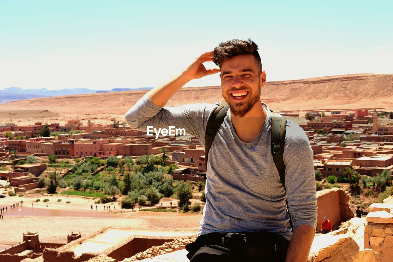 Portrait of smiling young man against sky