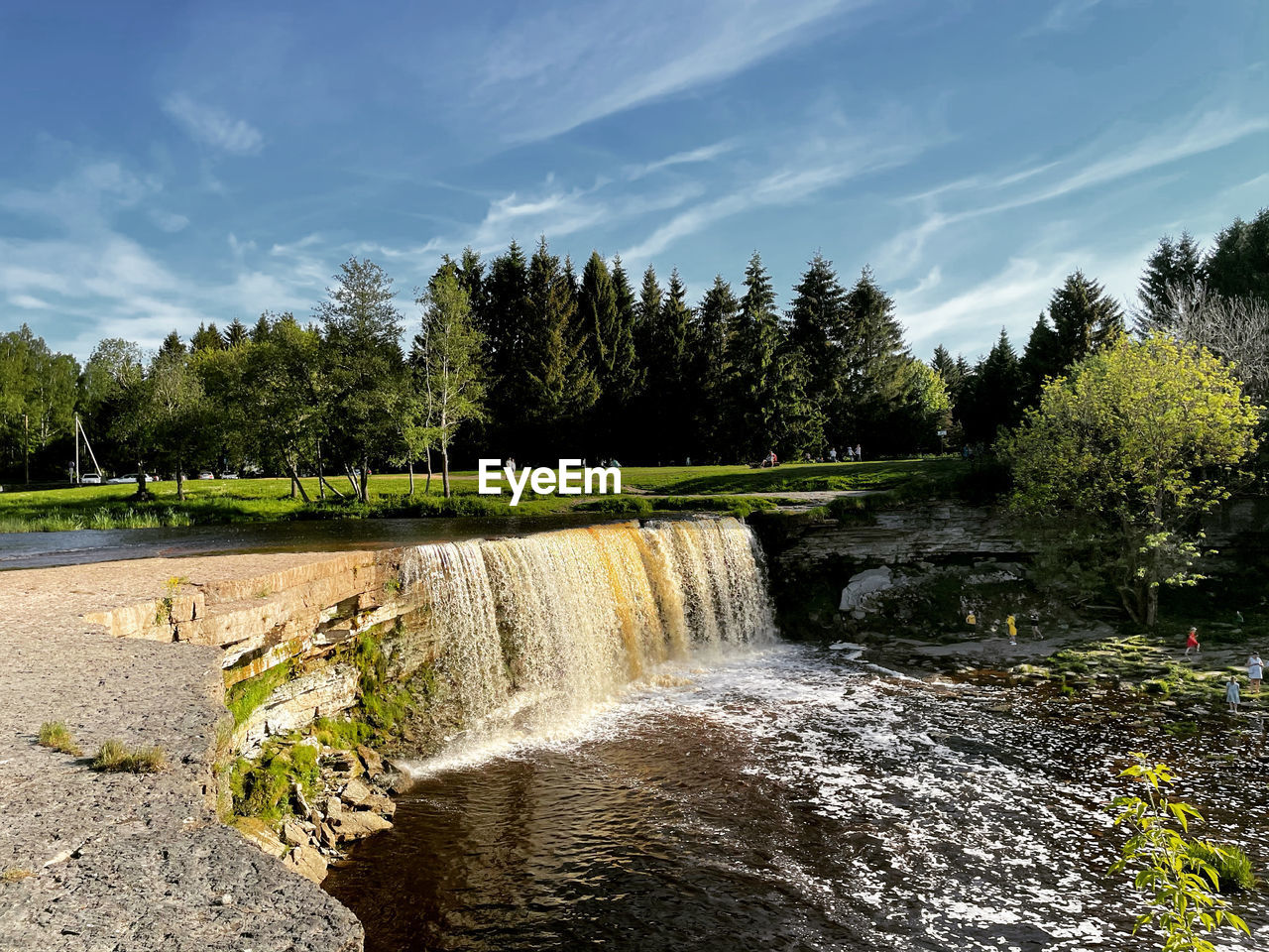 Scenic view of waterfall in forest against sky