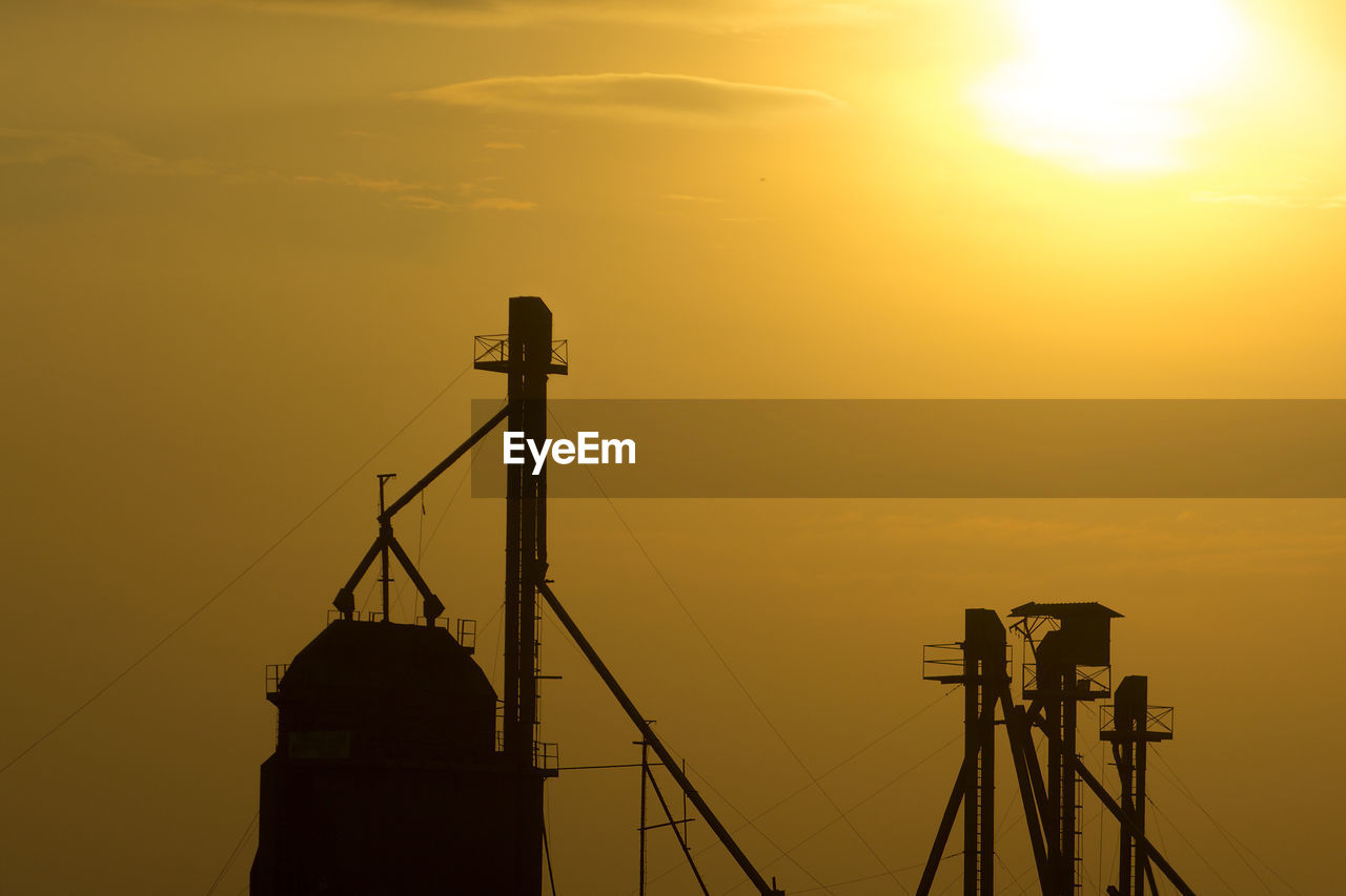 SILHOUETTE CRANE AGAINST ORANGE SKY