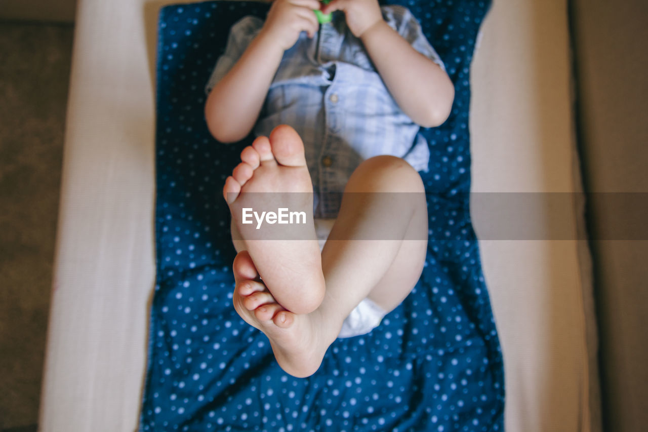 Directly above shot of boy lying on bed at home