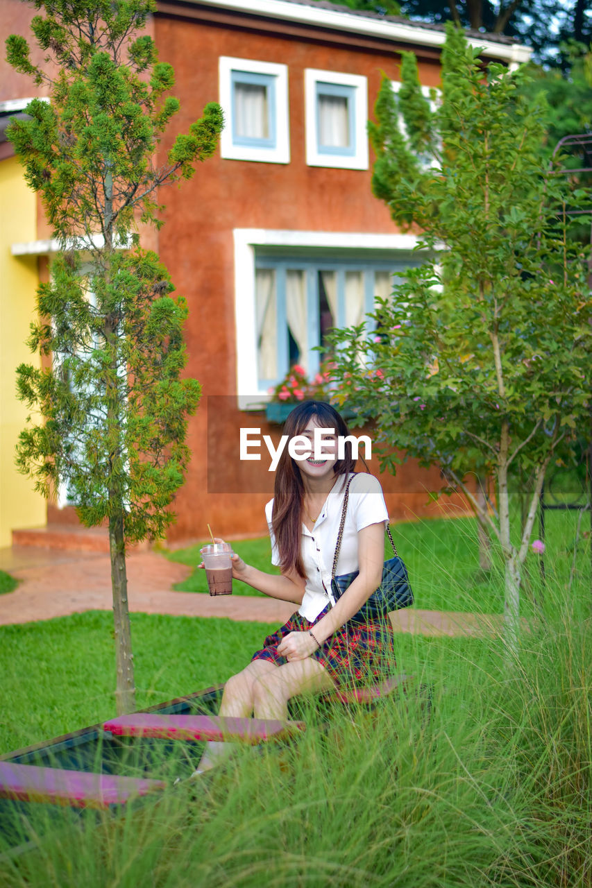 portrait of young woman sitting on grass