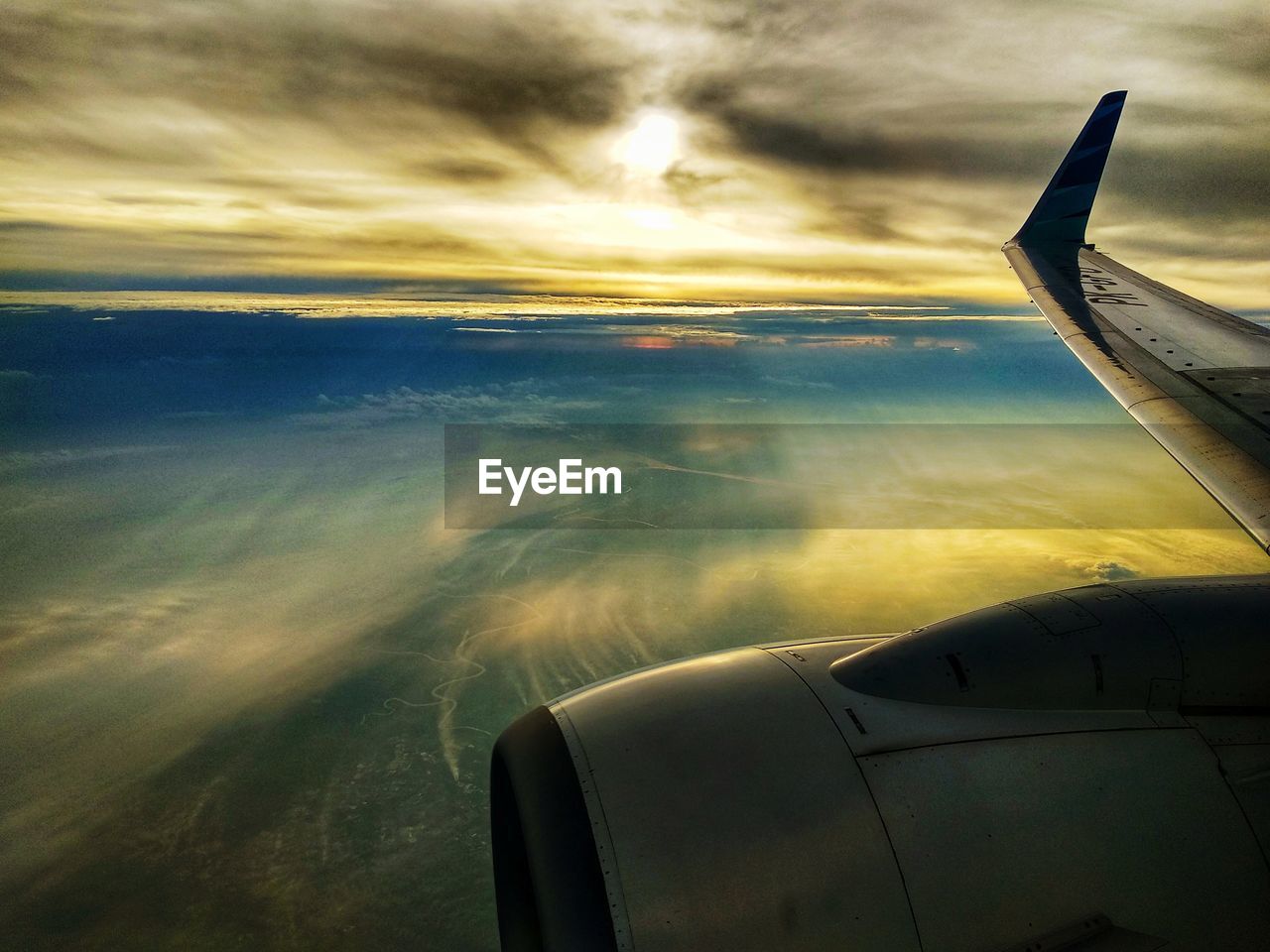 AIRPLANE WING AGAINST CLOUDY SKY