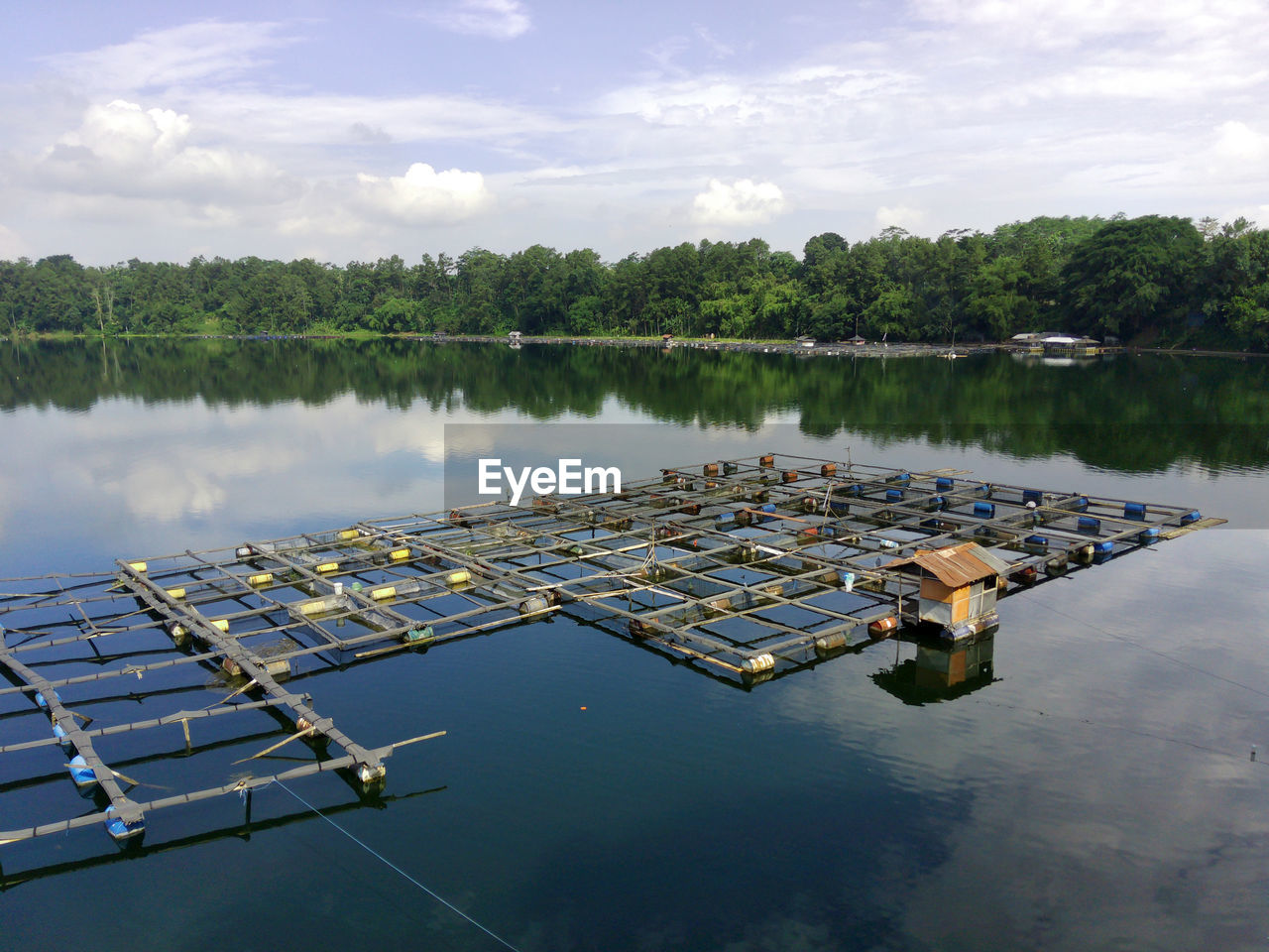 water, reflection, dock, lake, reservoir, nature, sky, nautical vessel, cloud, marina, environment, no people, tree, plant, transportation, tranquility, day, beauty in nature, outdoors, pier, business, in a row, boating, finance, vehicle, environmental conservation, channel, waterway, scenics - nature