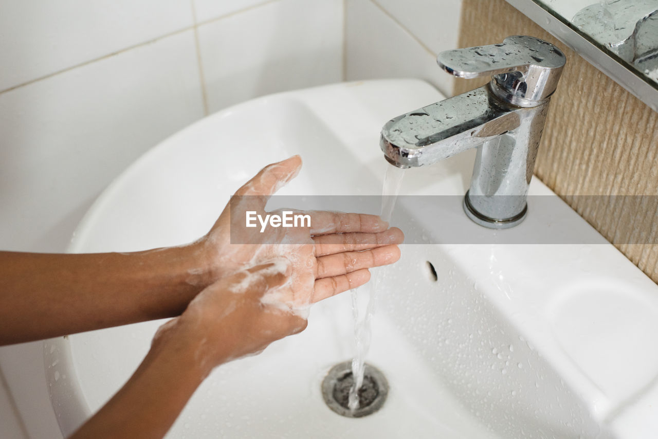 Cropped image of person washing hands