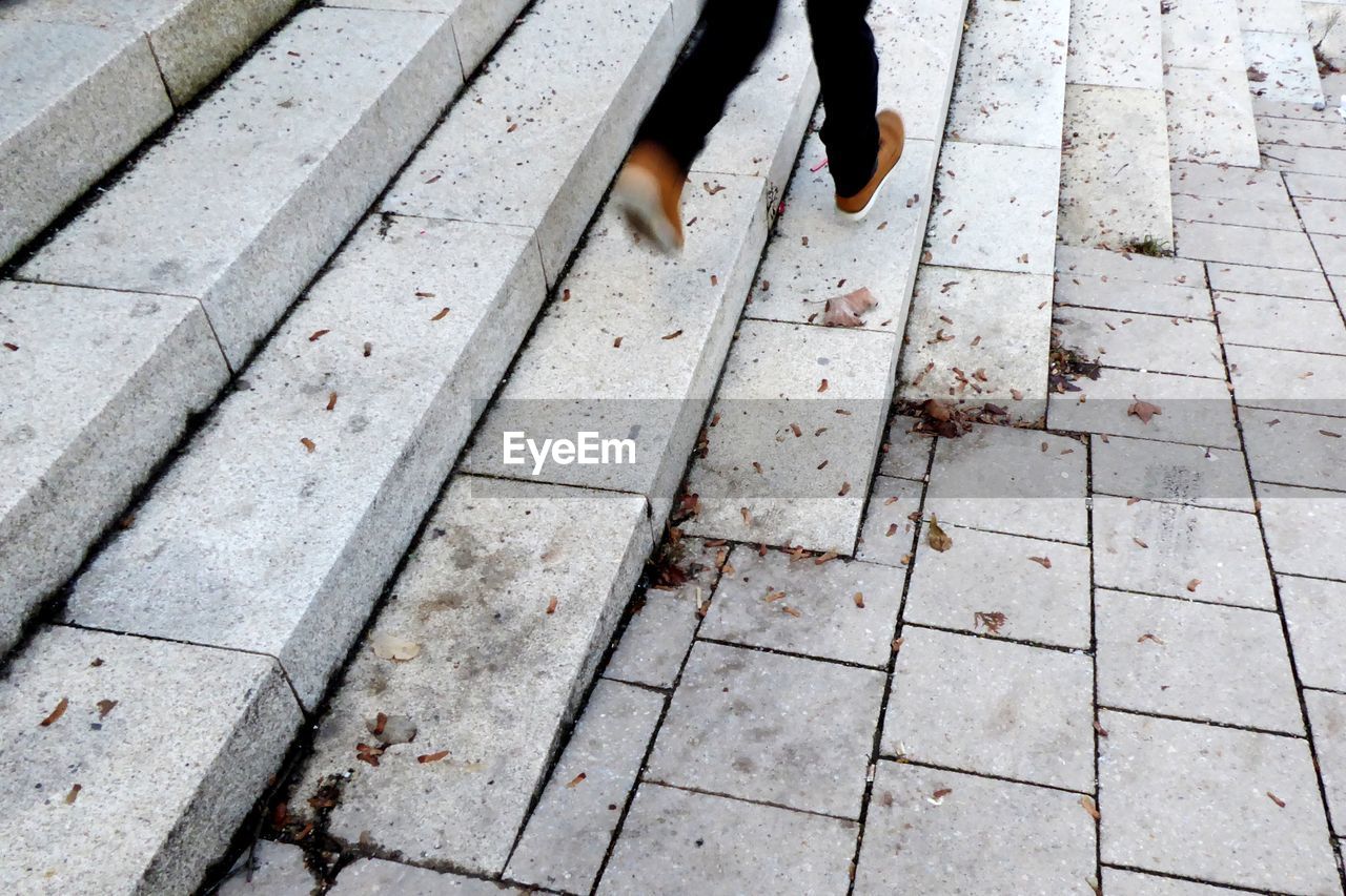 Low section of person running on staircase outdoors