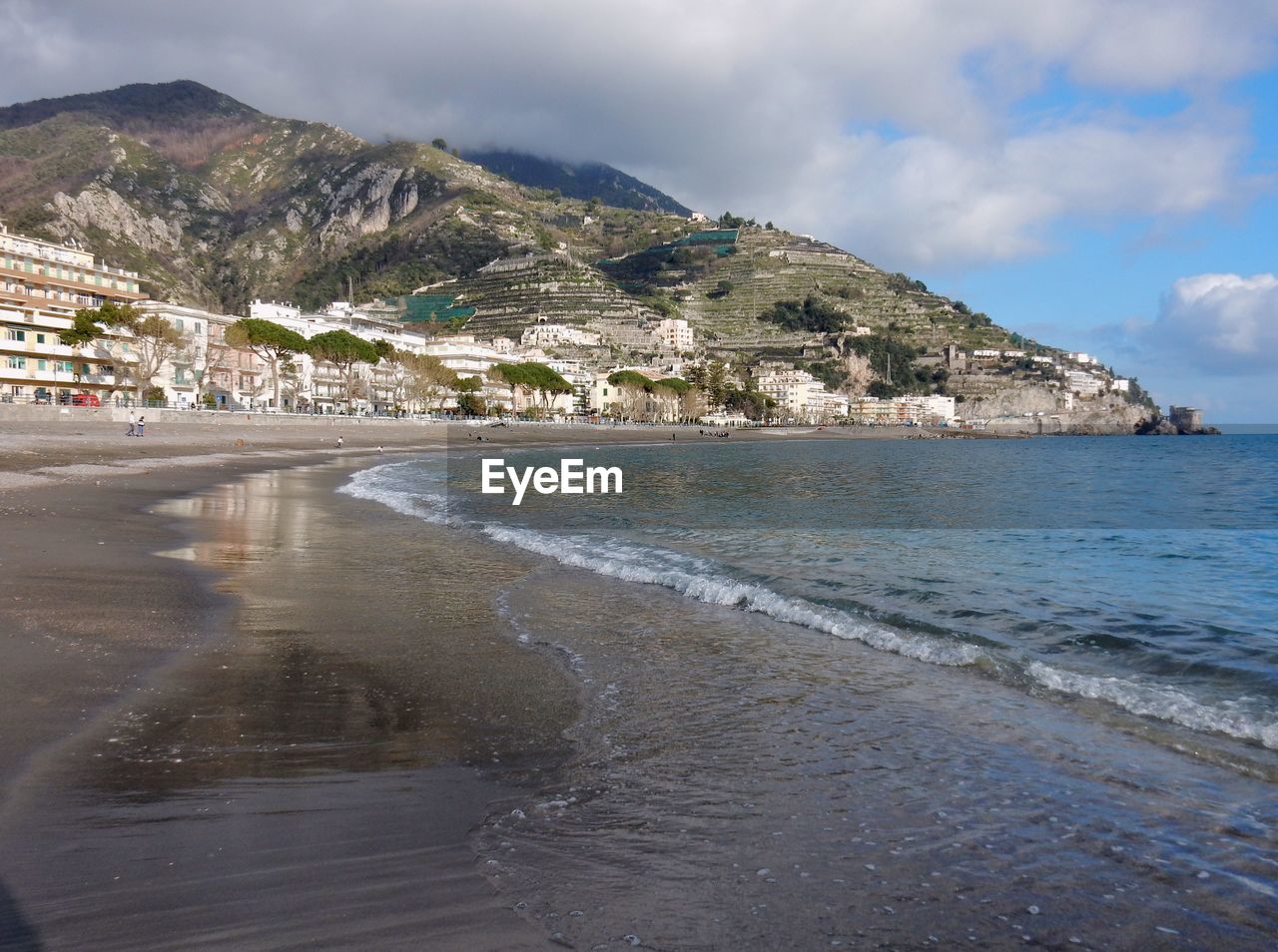 Scenic view of beach by city against sky