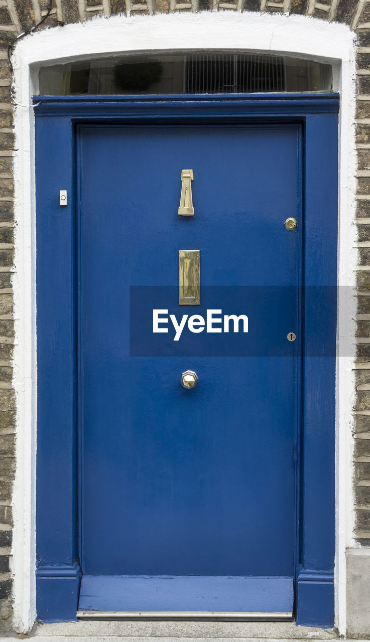 CLOSE-UP OF BLUE DOOR WITH TEXT ON METAL