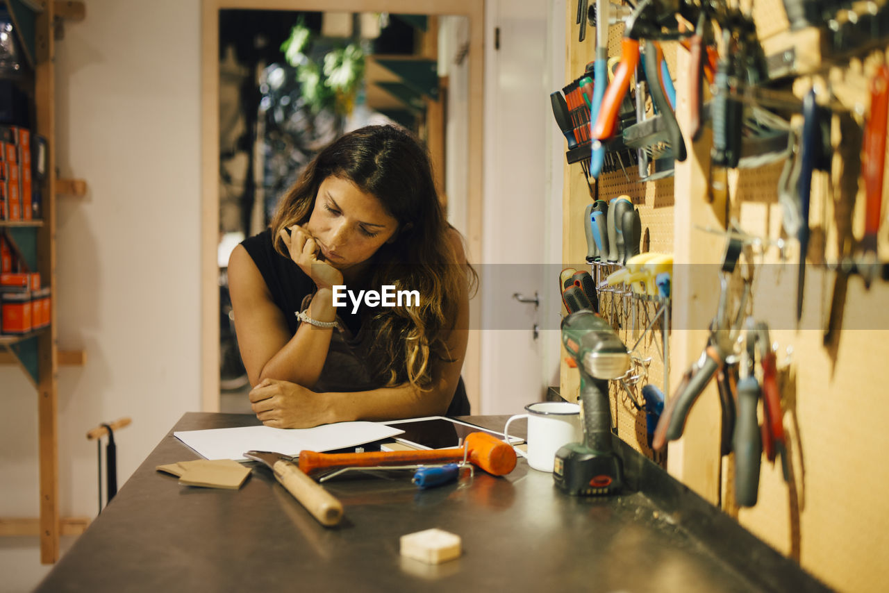 Businesswoman examining document at bicycle shop