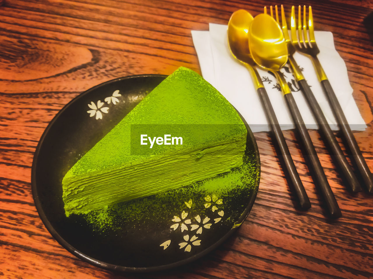 CLOSE-UP OF GREEN TABLE AND WOOD ON WOODEN FLOOR