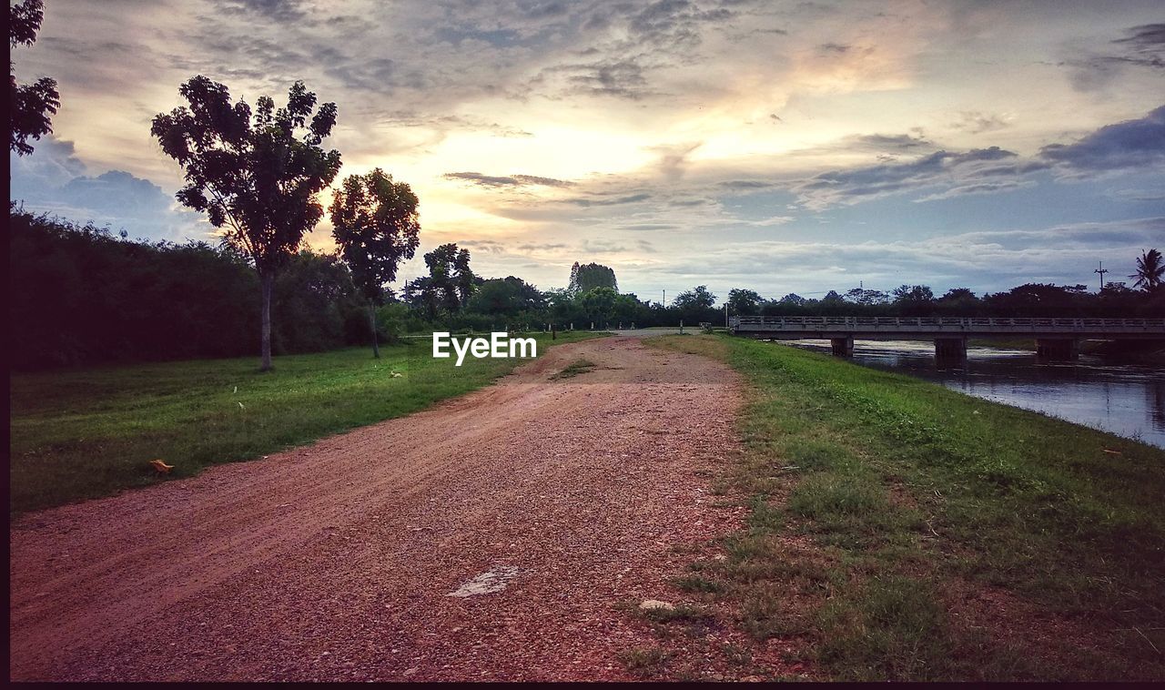 EMPTY ROAD ALONG LANDSCAPE AT SUNSET