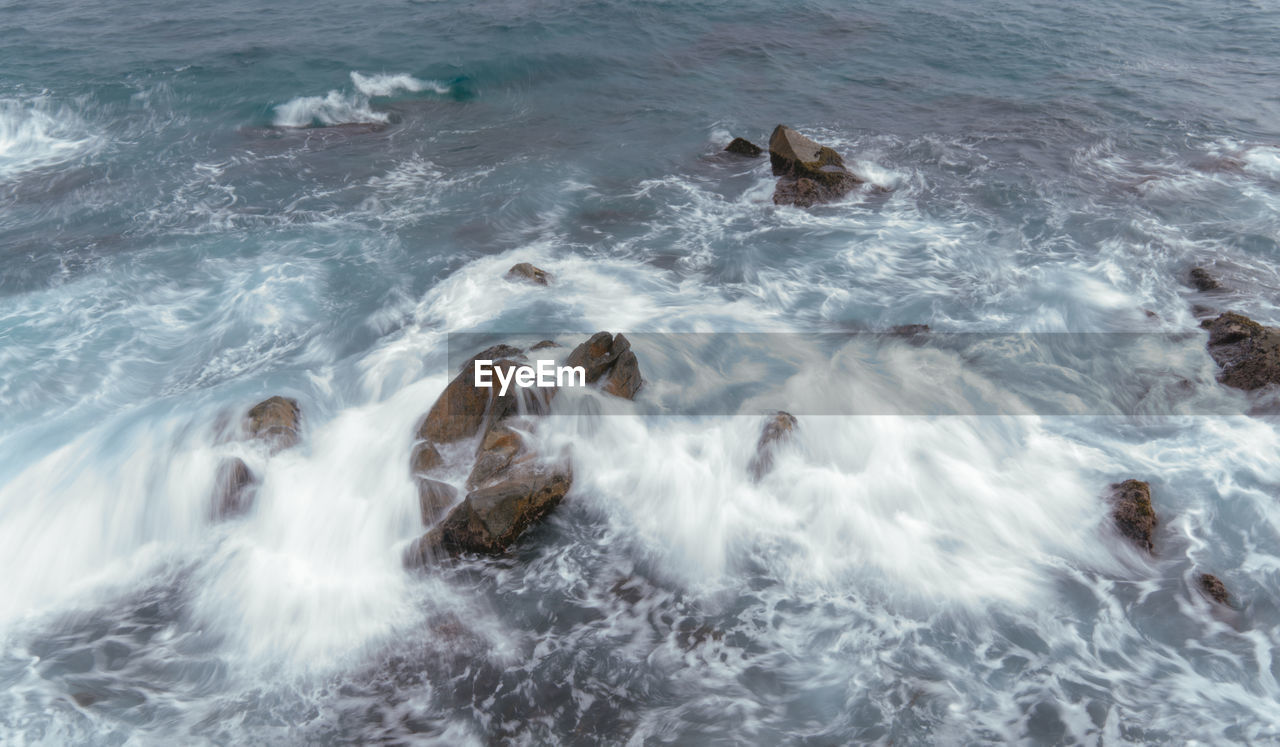 HIGH ANGLE VIEW OF SURF ON BEACH