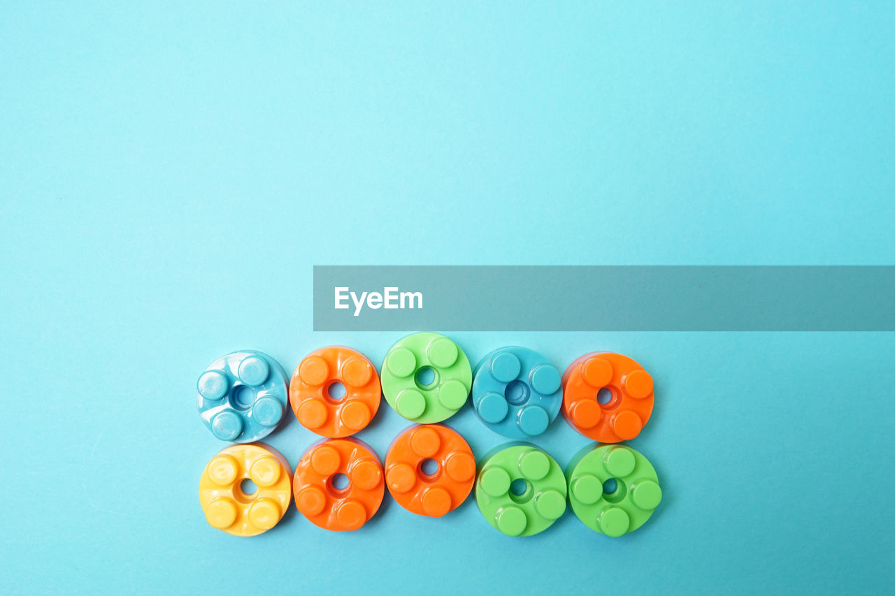 HIGH ANGLE VIEW OF MULTI COLORED CANDIES ON BLUE BACKGROUND