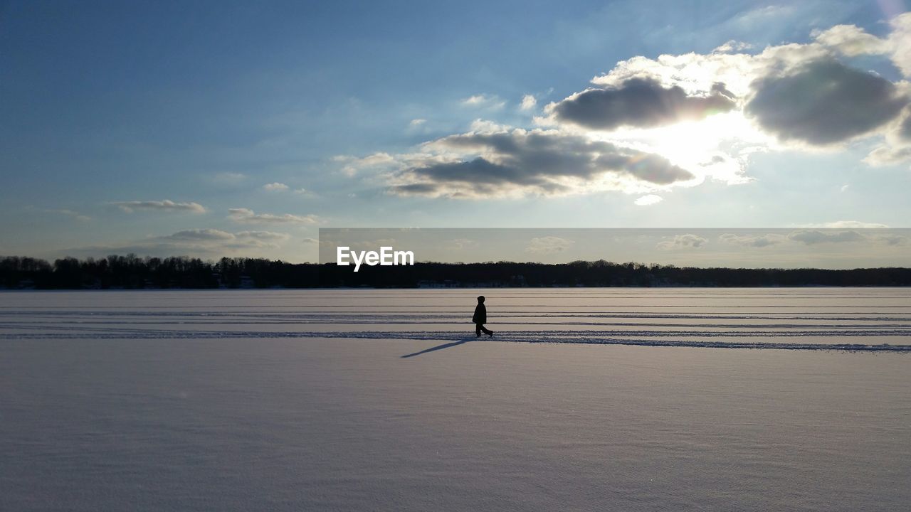 Person walking on snow covered landscape