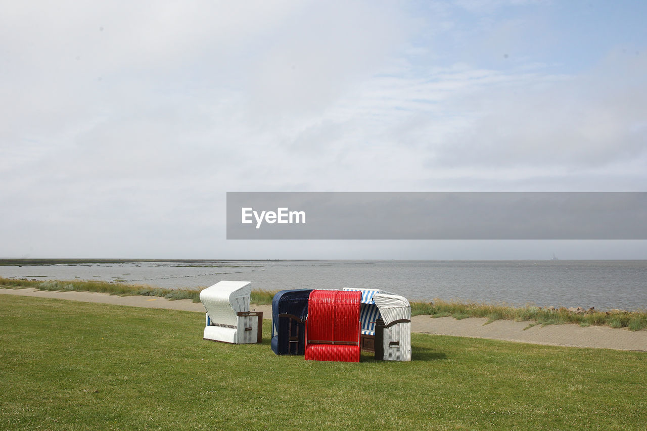 HOODED BEACH CHAIR ON FIELD AGAINST SEA