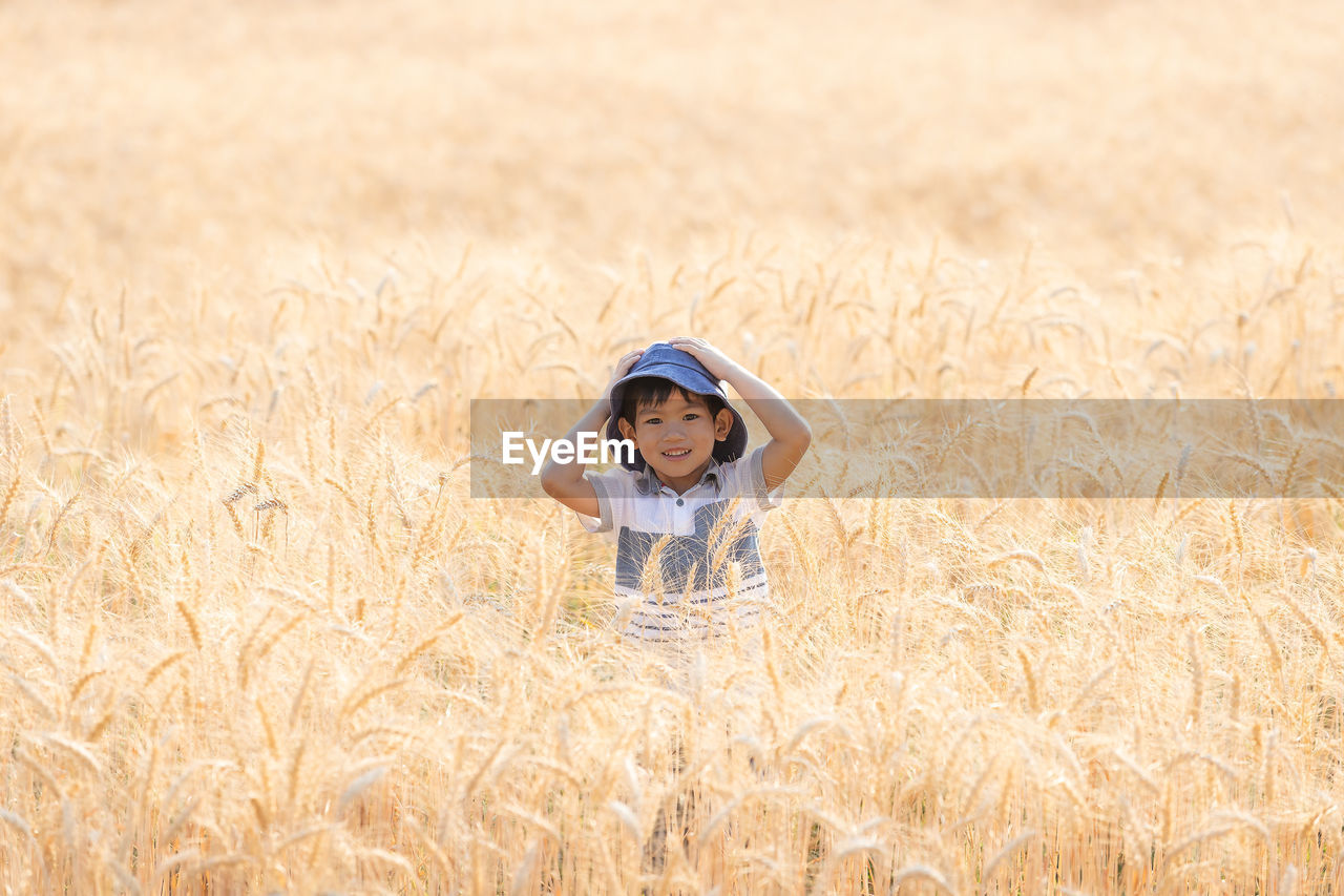 Portrait of smiling boy standing on field