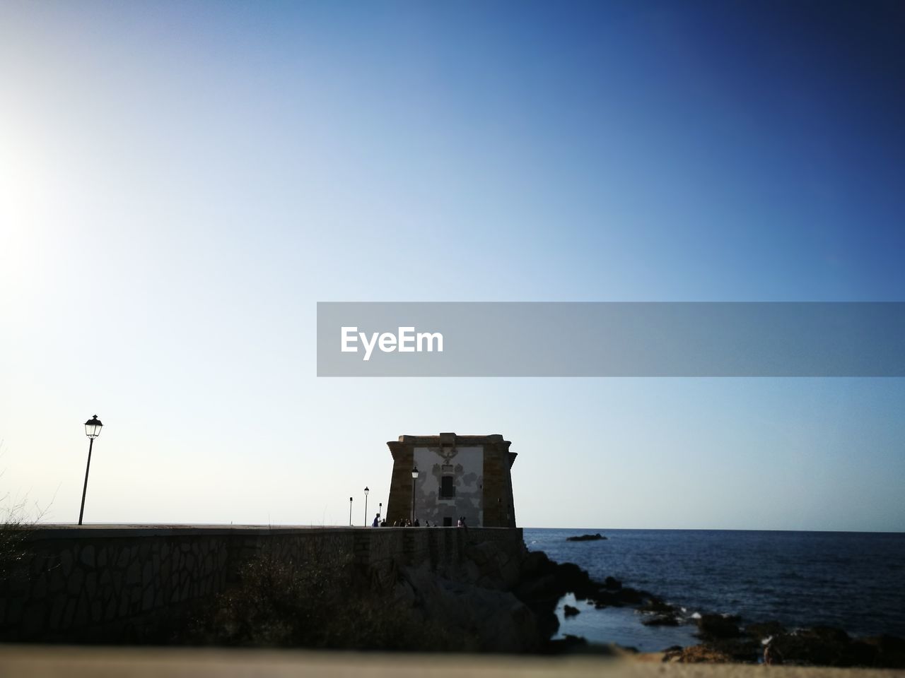 Built structure by sea against clear sky