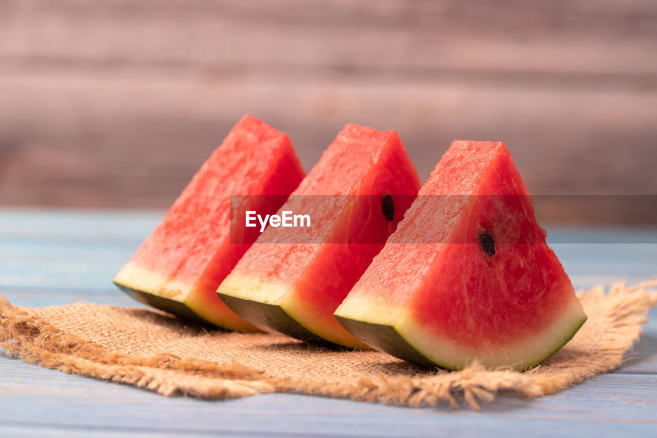 Close-up 3 pieces of watermelon slices on the wooden table