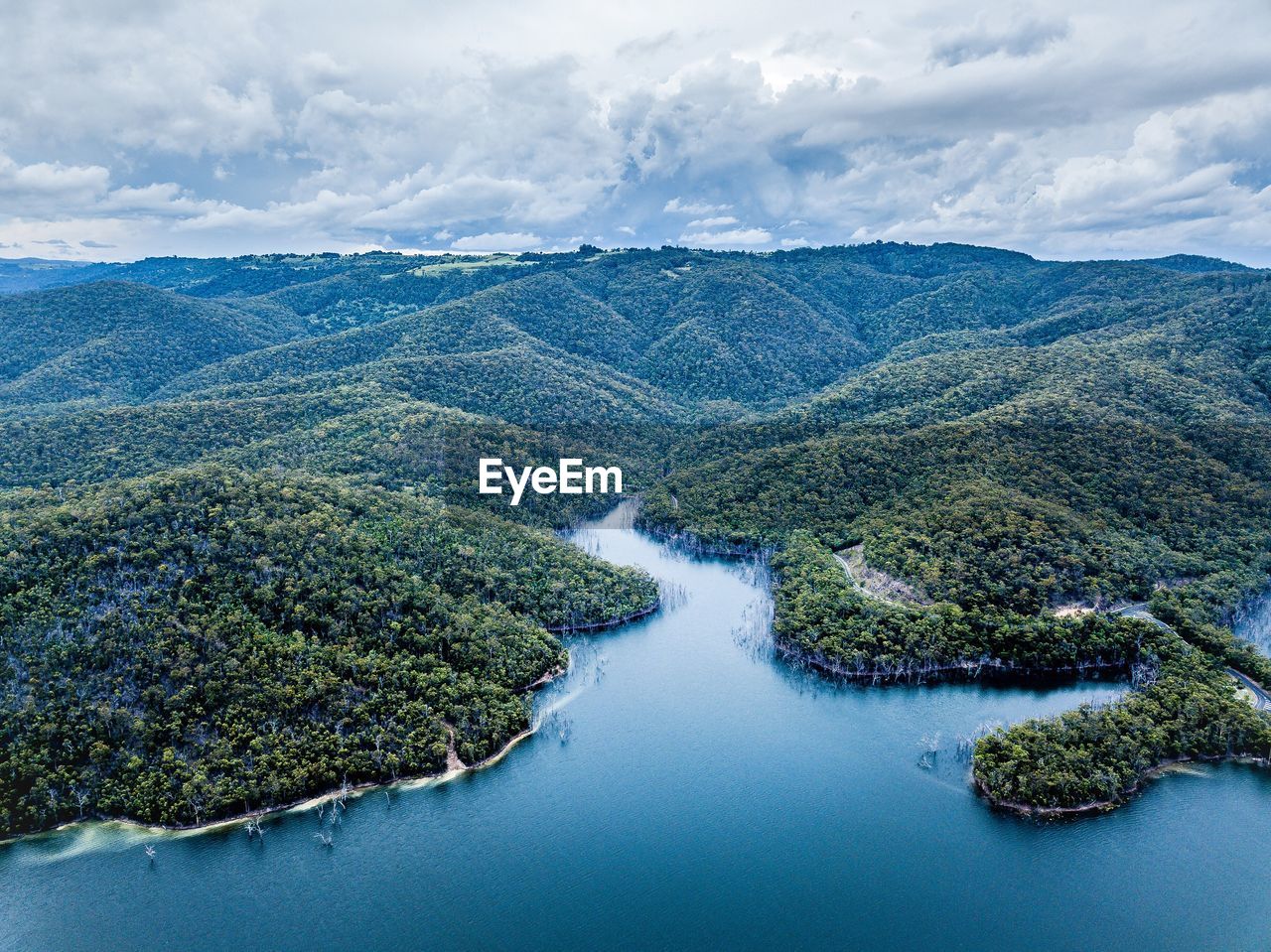 Aerial view of river amidst trees against sky