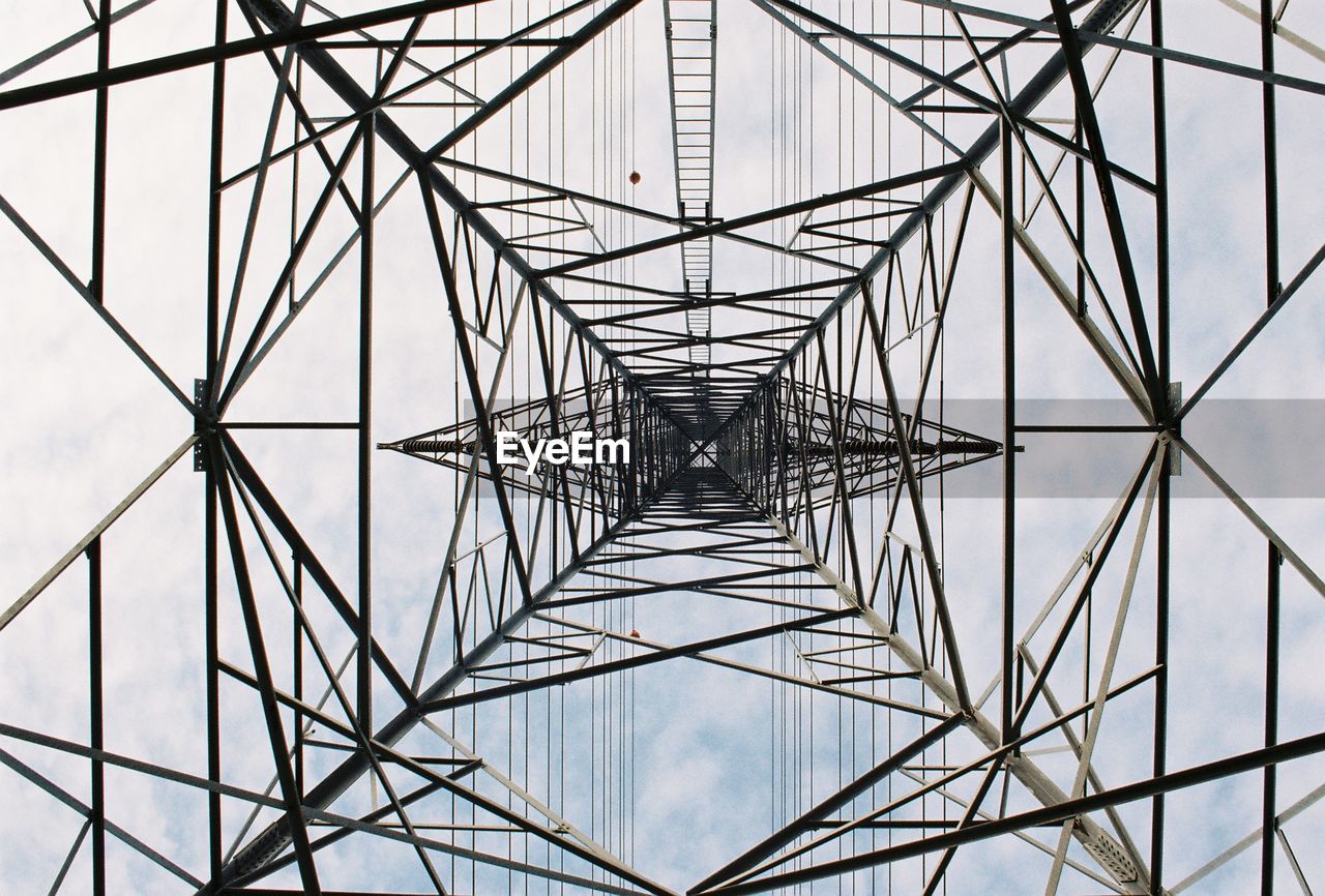 Directly below shot of electricity pylon against sky
