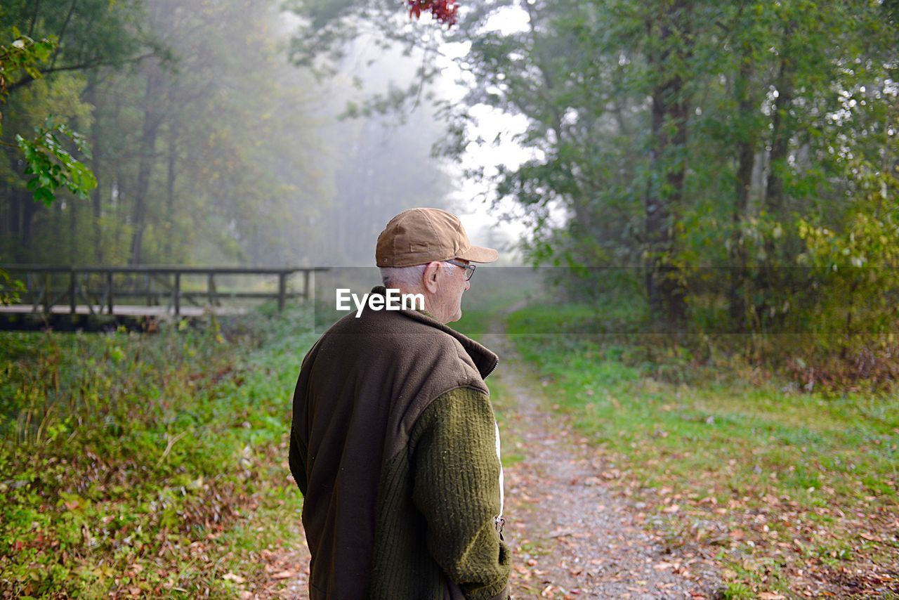 Senior man standing in forest