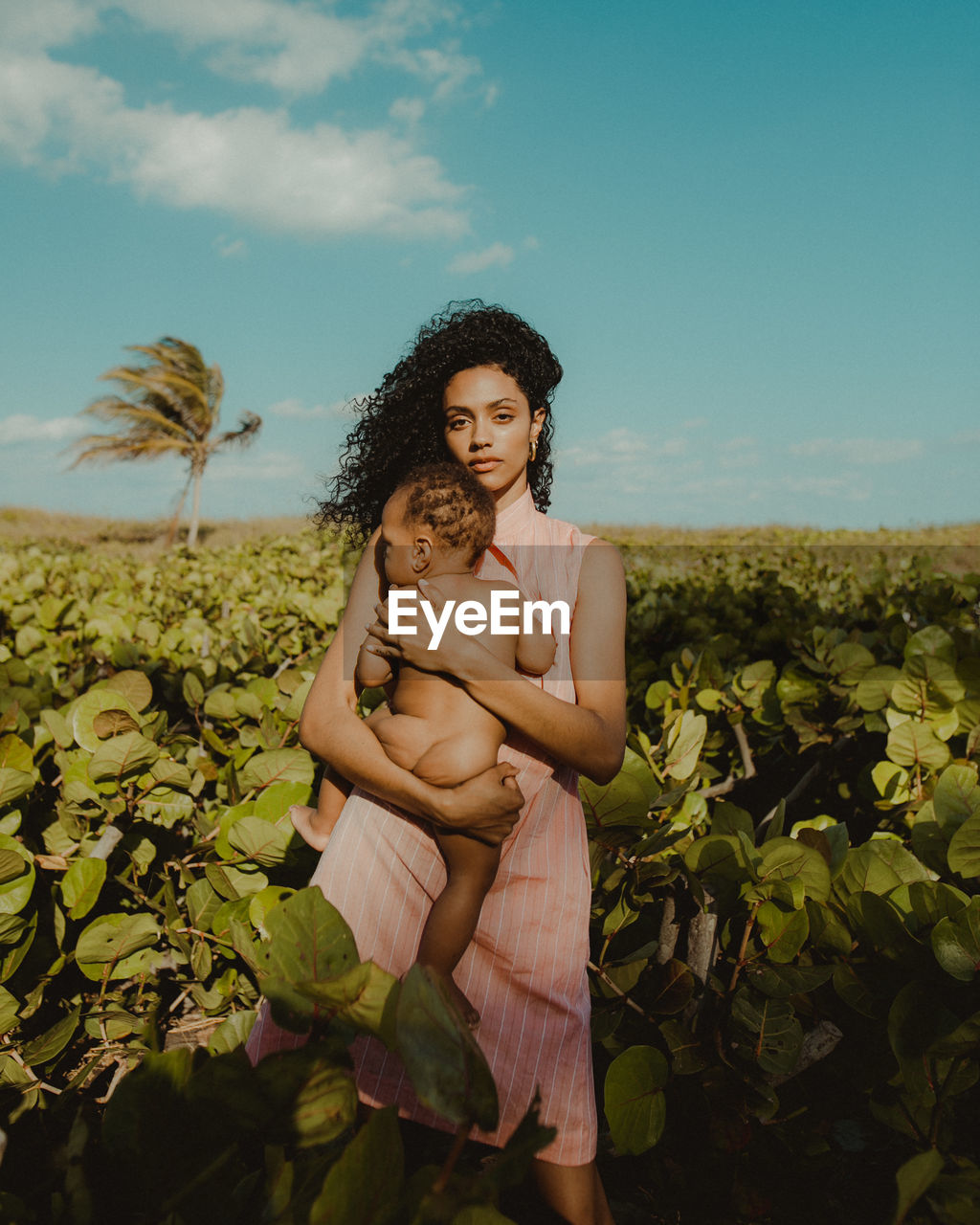 PORTRAIT OF WOMAN STANDING ON FIELD