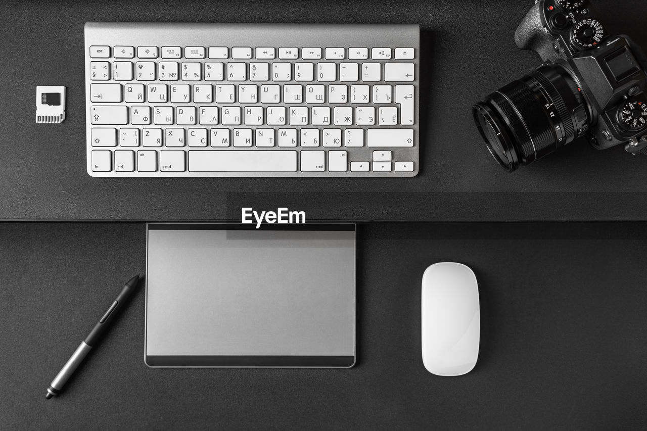 Photographers  or designer workspace. photo camera, keyboard, graphics tablet equipment