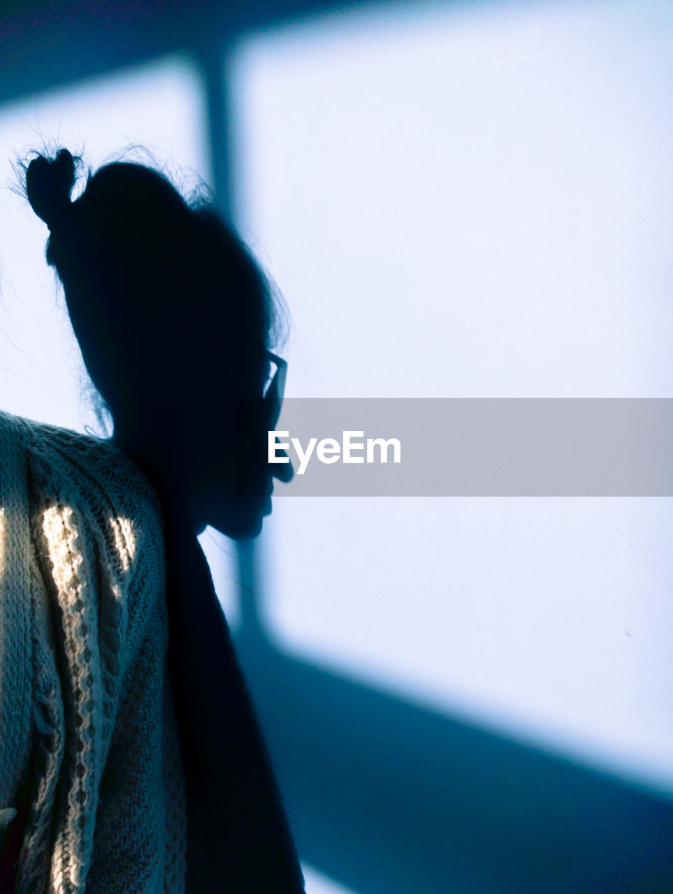 Cropped shoulder of woman with shadow on wall