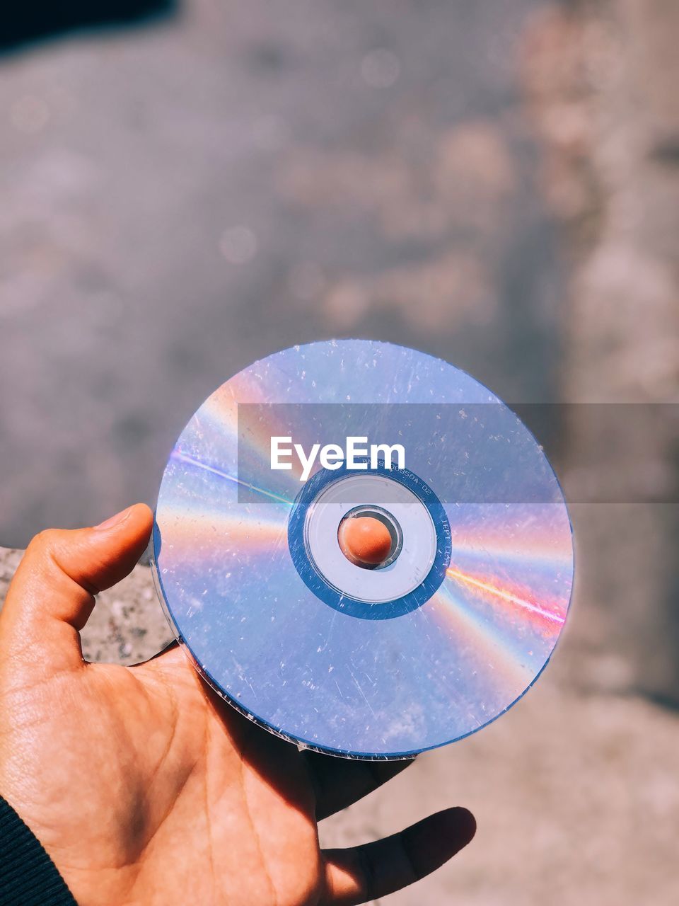 Cropped hand holding compact disc