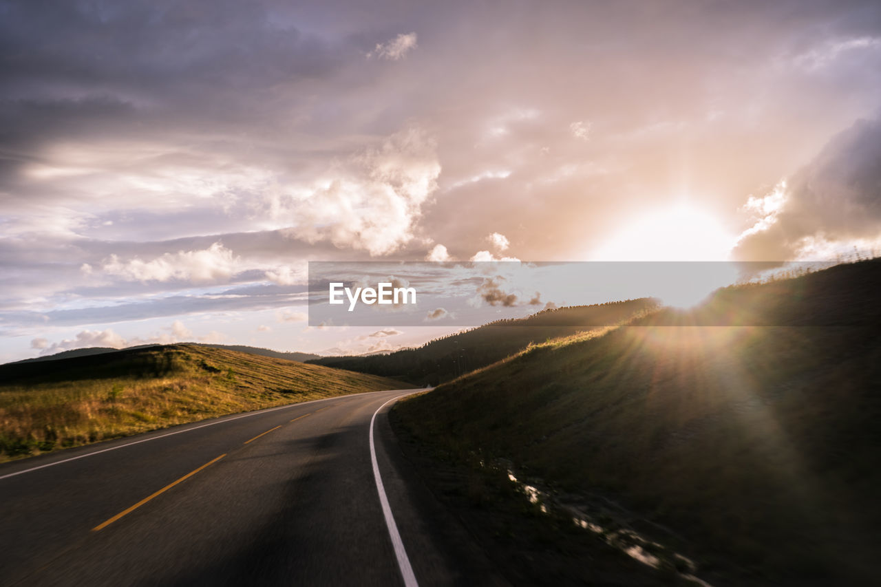 Road amidst landscape against sky during sunset