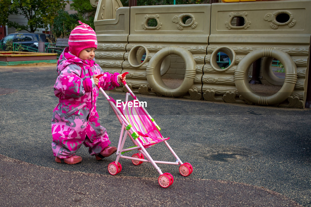 Cute kid walking with baby stroller