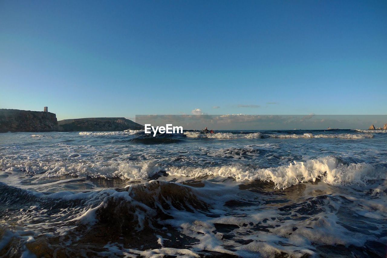 Scenic view of sea against clear blue sky