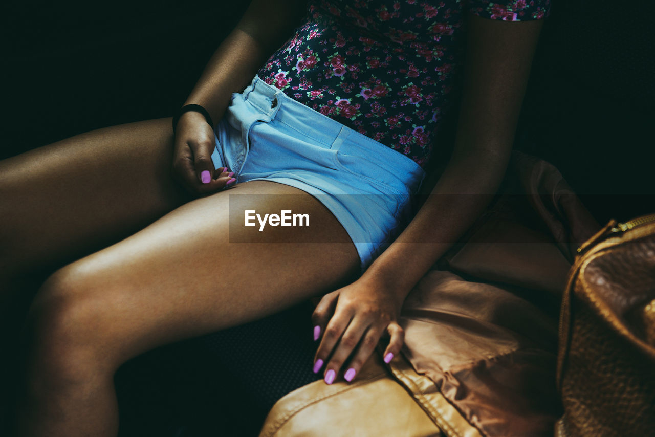 Midsection of woman sitting on sofa