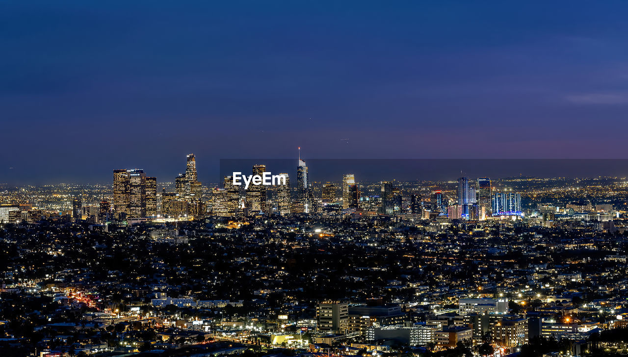 High angle view of illuminated buildings against sky at night