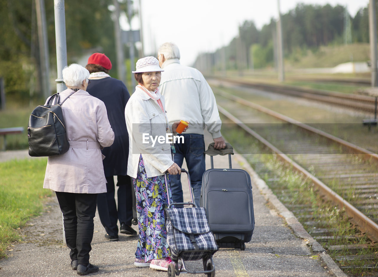 Group of seniors elderly old people with luggage waiting for a train to travel