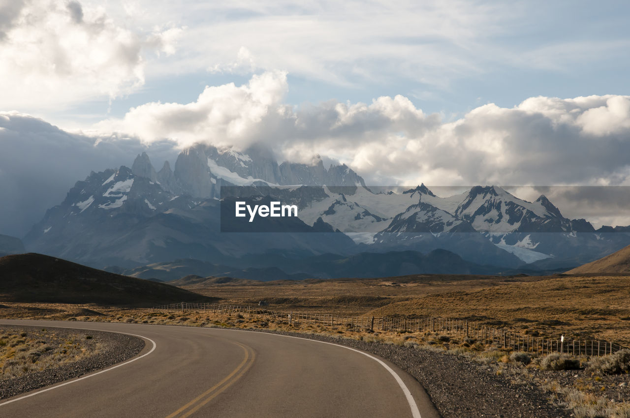 Empty road against mountains during winter