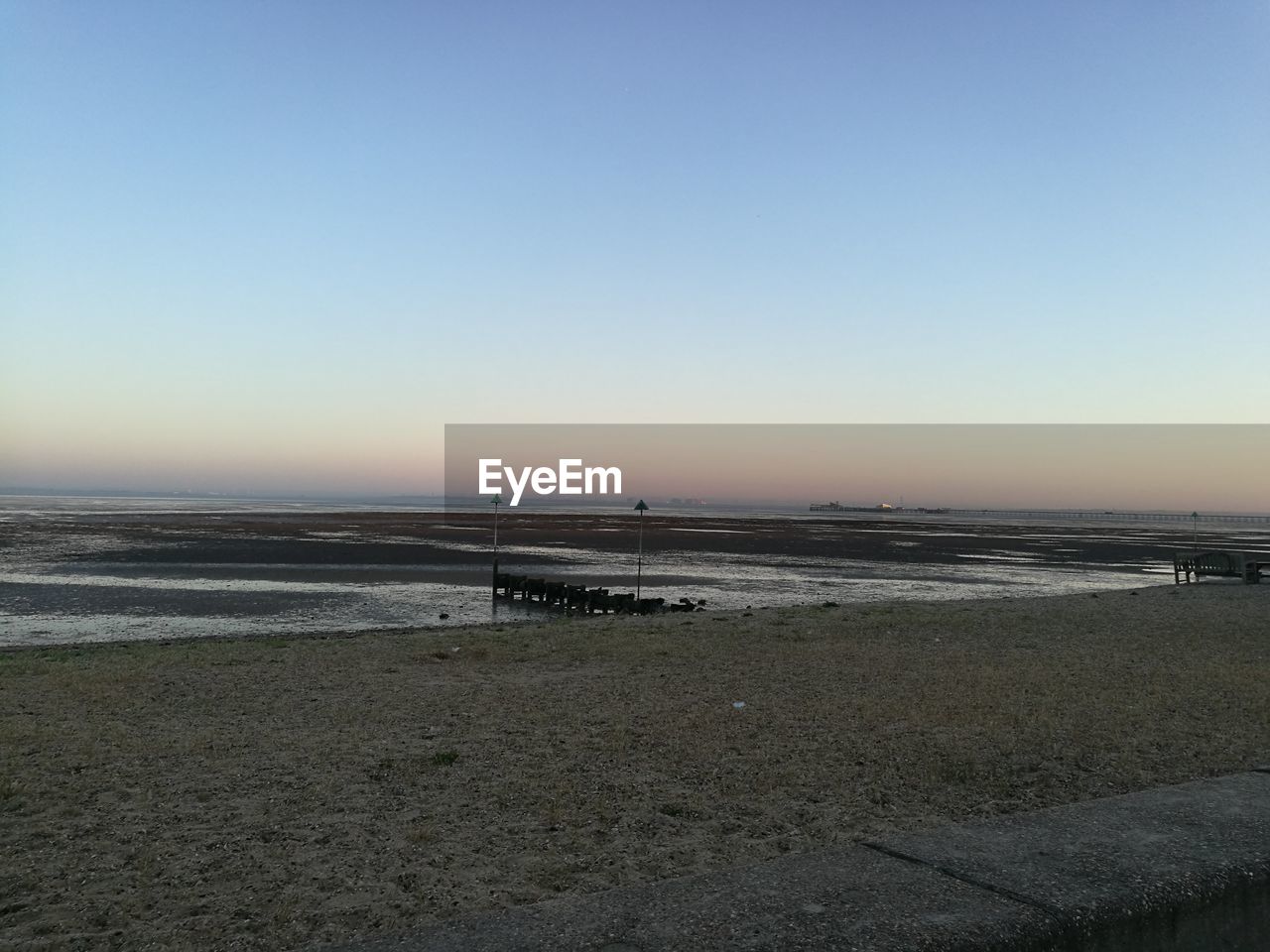 SCENIC VIEW OF BEACH AGAINST CLEAR SKY AT SUNSET