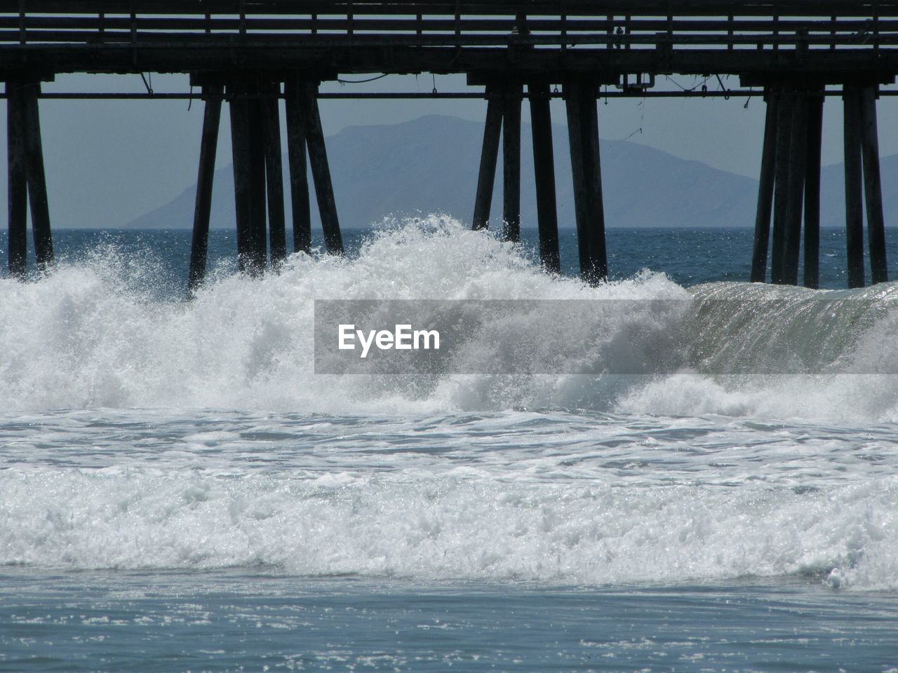 Waves splashing on pier in sea