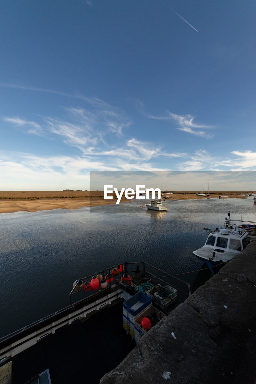 HIGH ANGLE VIEW OF HARBOR BY SEA AGAINST SKY