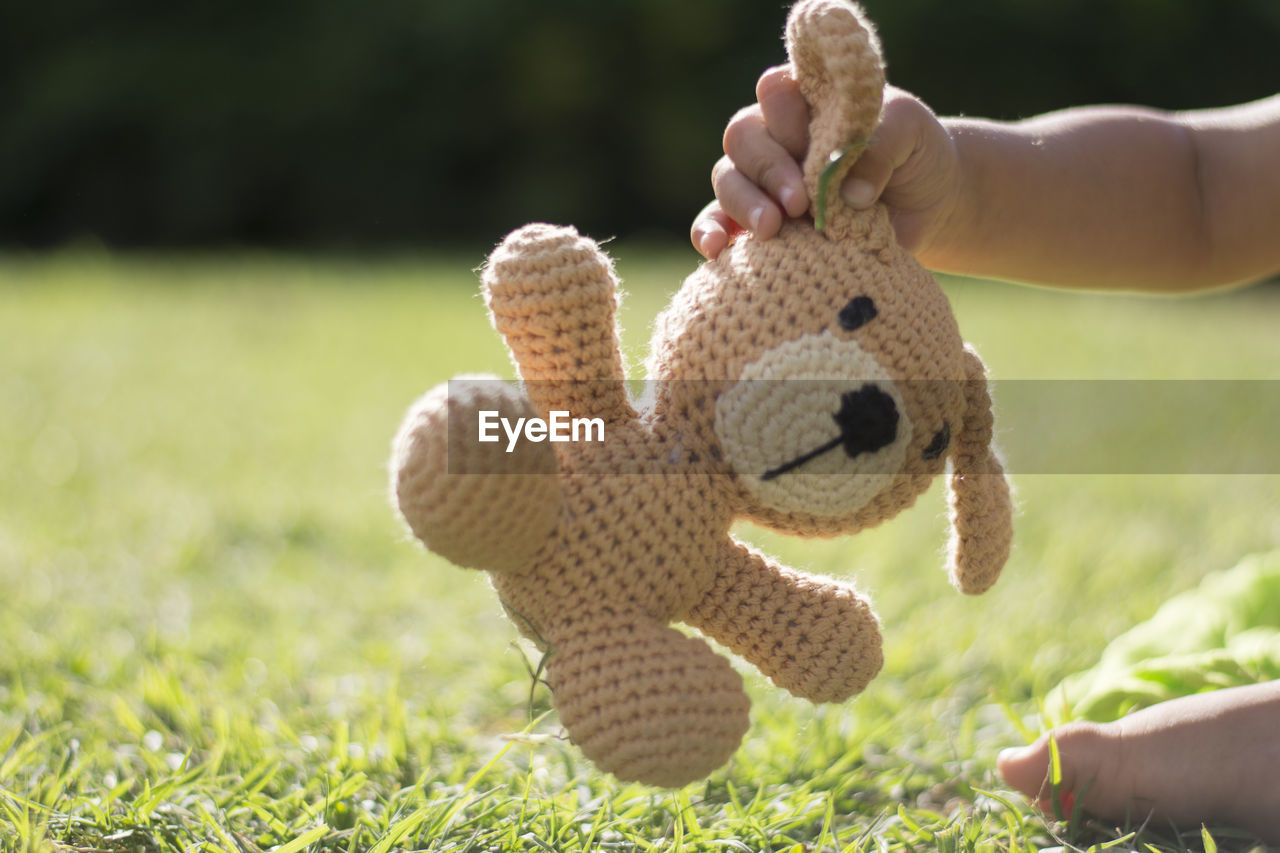 Boy holding his stuffed animal in the park