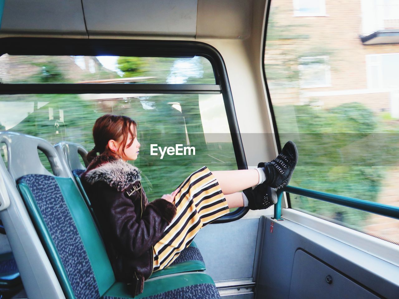 Side view of girl sitting in train