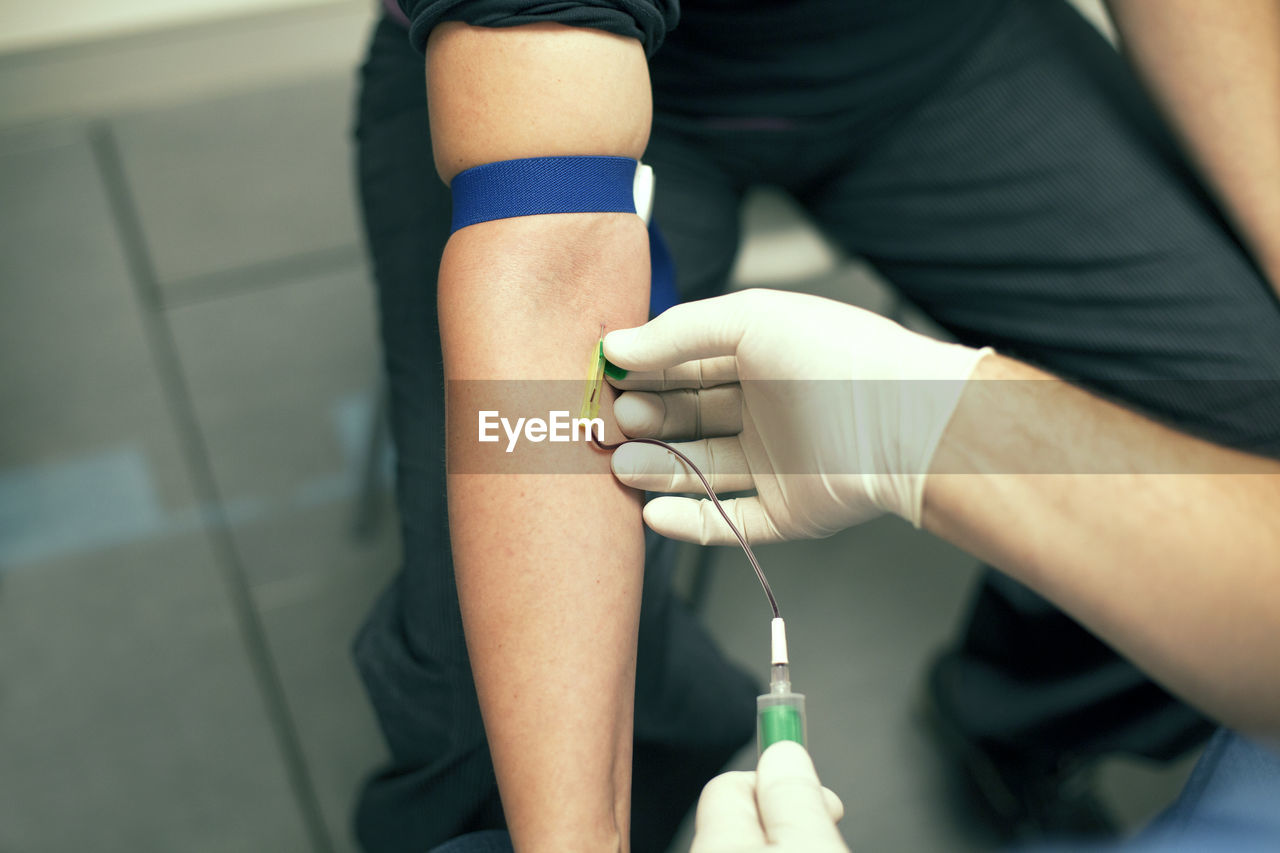 Cropped image of doctor injecting iv drip needle