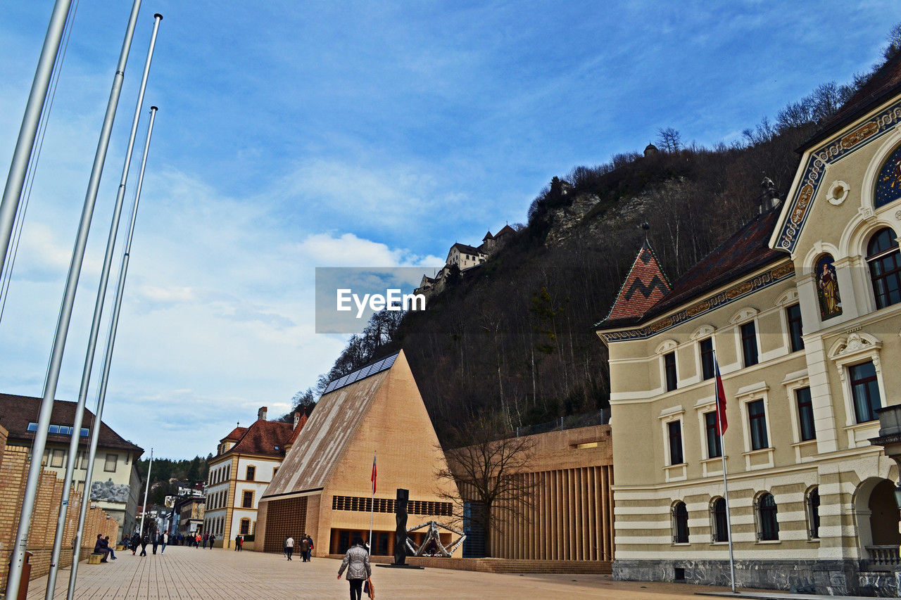 architecture, built structure, building exterior, town, sky, building, city, nature, landmark, travel destinations, road, cloud, tourism, travel, street, history, transportation, the past, day, adult, walking, outdoors, urban area, men, group of people, lifestyles, cityscape, house, vacation, neighbourhood, facade, sunlight