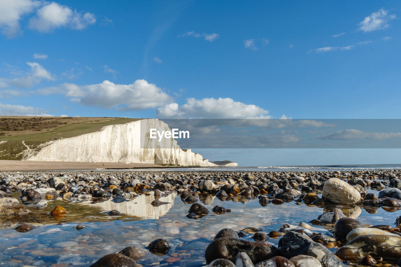 FLOCK OF ROCKS IN SEA AGAINST SKY