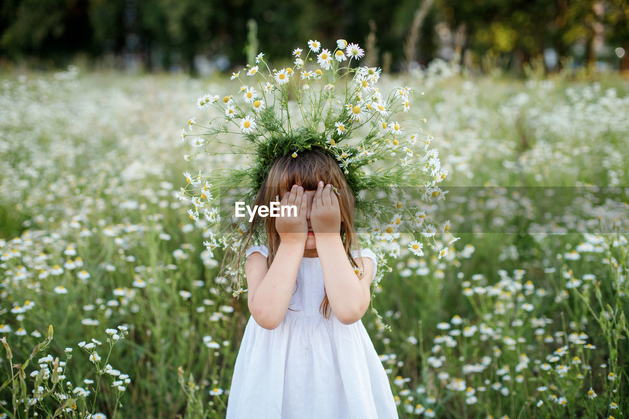 Portrait of woman standing on flowering plant