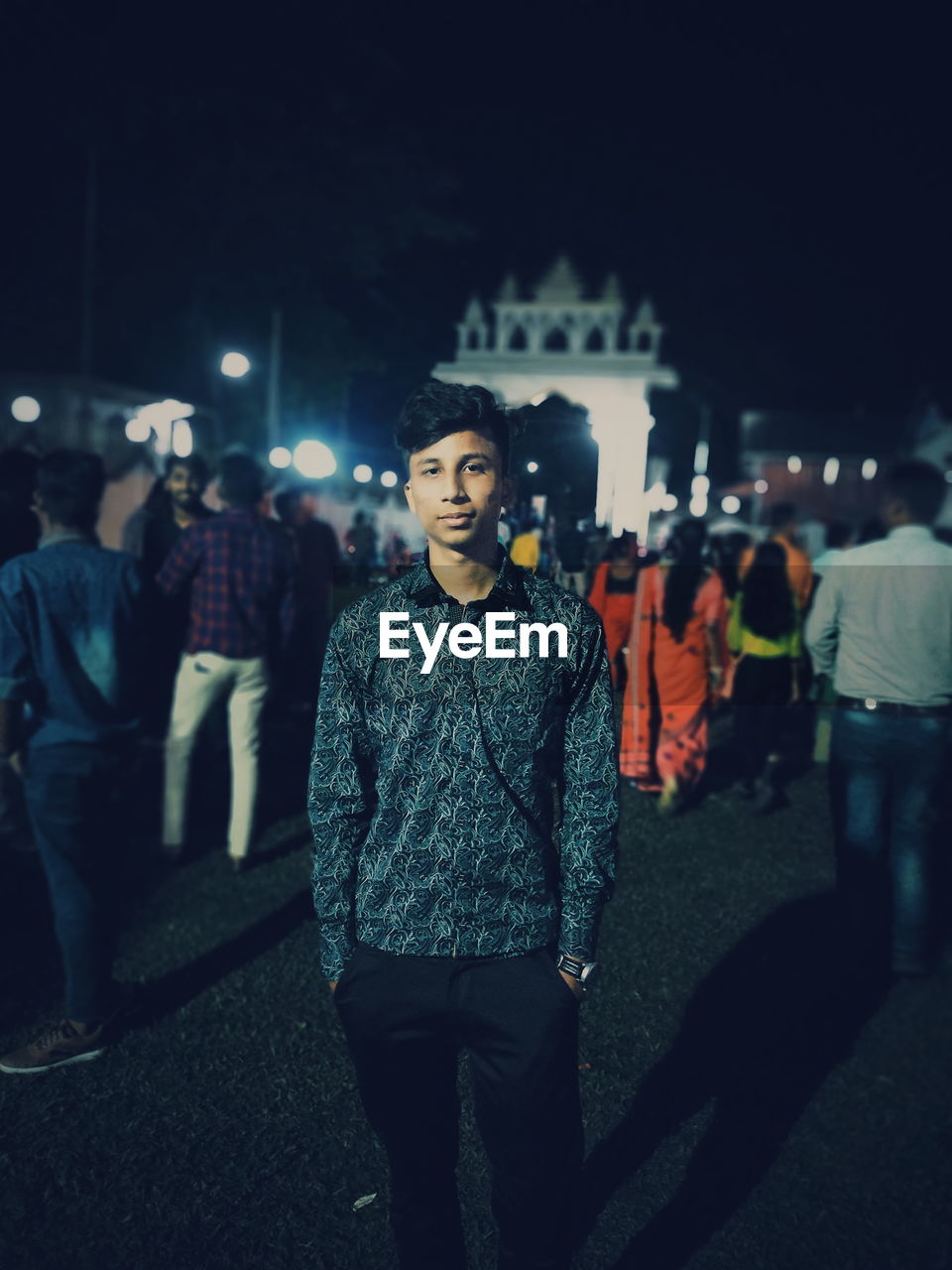 Portrait of young man standing city at night