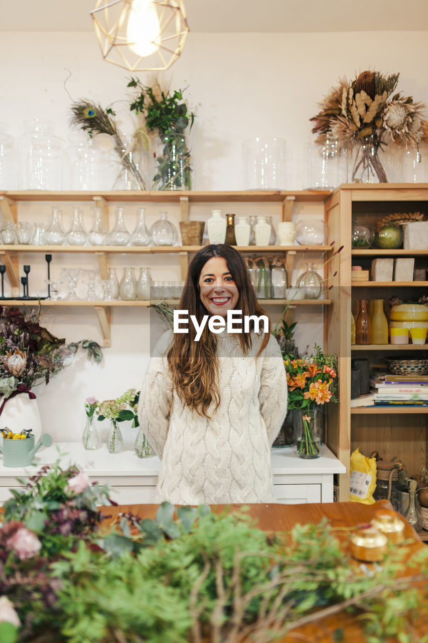 Smiling craftswoman standing at flower shop